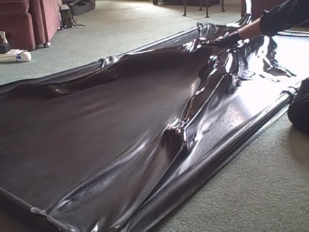 Fi In The Latex Vac Bed - Fi has slipped, completely naked, into a black, latex vac bed.  It is her first experience and she is trembling slightly.

the bed has been zipped shut  and the power switched on.  The pump slowly withdraws the air from the bed, allowing fi to feel the latex compress on to her skin.

what she doesn't expect is the latex hand that drips polish all over the latex covering her naked body and then starts to shine her up.  Watch the clip to see her response!